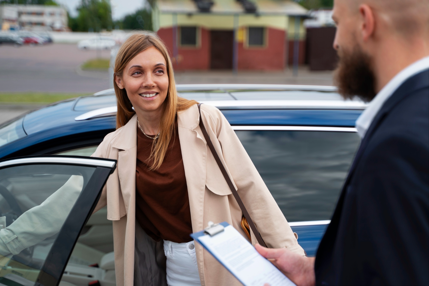 Femme et homme  ct d'une voiture parlant d'assurance